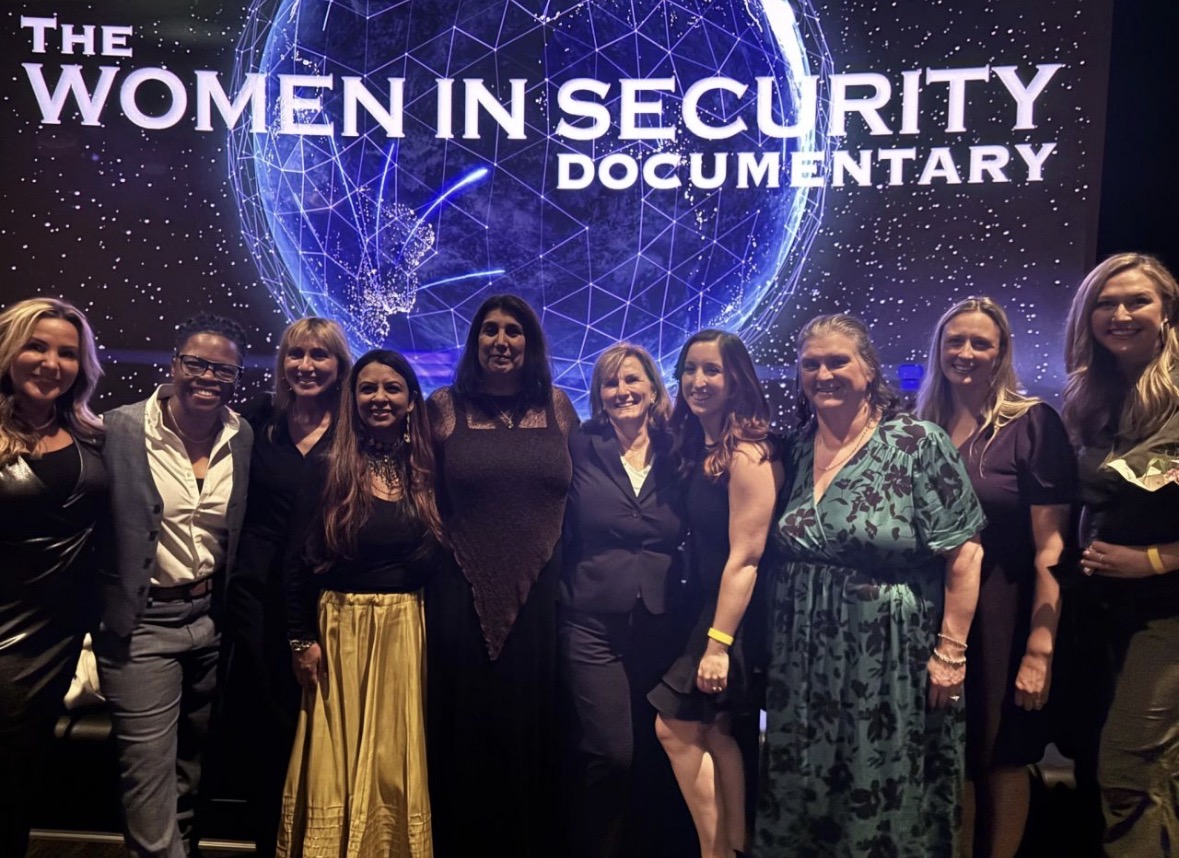 Women photographed close to the documentary title and globe artwork at a screening reception.